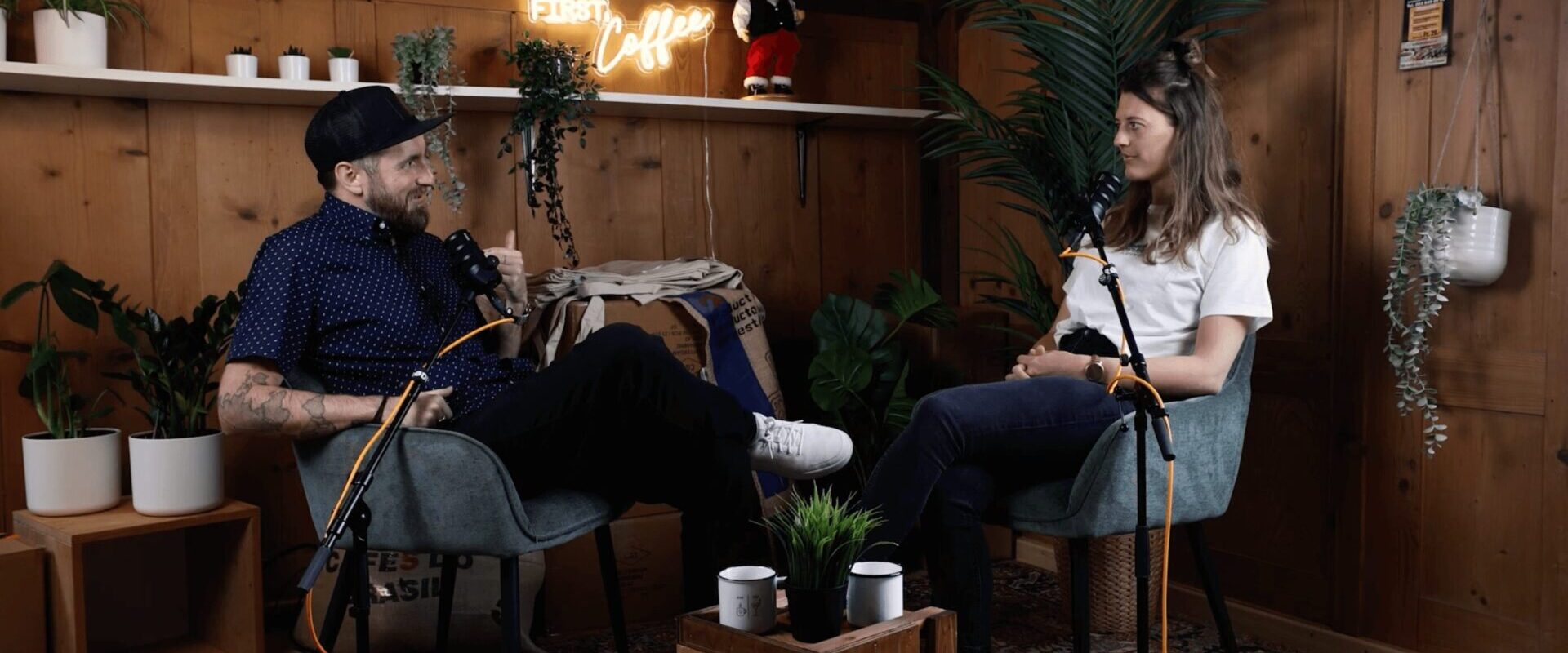 Auf dem Bild sitzen Livia und Bastian in ihrem Podcast setup im Ostinges Büro und nehmen die erste folge auf.